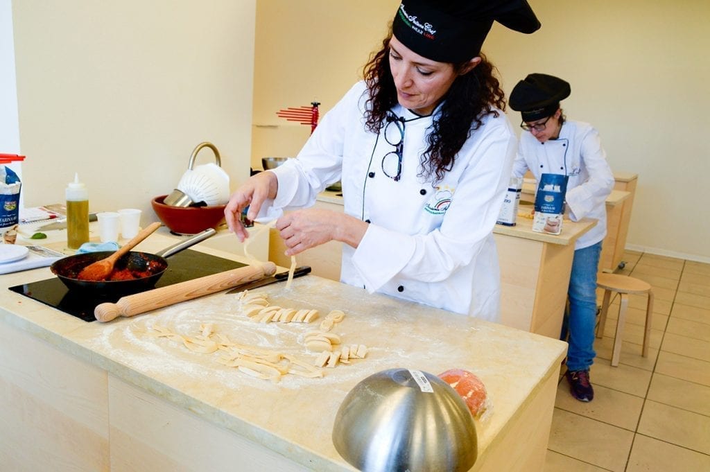 a female student preparing tagliatelle during the course of pasta making